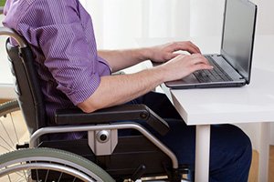 Disabled sitting at a desk and working on laptop